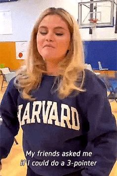 a woman in a blue sweatshirt holding a basketball