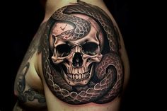 a skull and snake tattoo on the arm