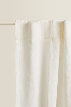 a white curtain hanging on the side of a window