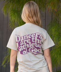 A favorite Albert Einstein quote with the dance crowd with an on-trend design printed on the back of a lightweight, sand colored tee. "Dancers are the athletes of God." - Einstein. Dancers of all styles will appreciate this inspirational quote. Wear this t-shirt while you're warming up for ballet and jazz class at the dance studio, or wear it out on the weekends with a pair of jeans to show off your passion. Classic fit, unisex sizing. Features a ribbed crewneck and double needle stitching on sl Albert Einstein Quotes, Einstein Quotes, Warming Up, Dance Studio, Sand Color, The Dance, Albert Einstein, Inspirational Quote, Einstein