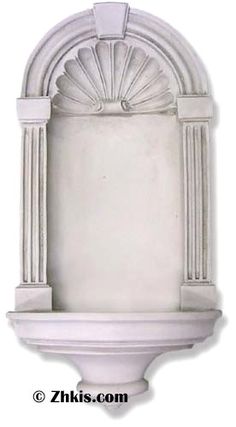 a white wall mounted fountain with an arch and columns on the front, side view