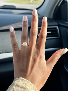 a woman's hand on the steering wheel of a car with a diamond ring