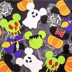 mickey mouse halloween cutouts are displayed on a black surface with spider webs and spooky decorations