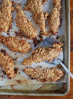 chicken tenders on a baking sheet with a spatula