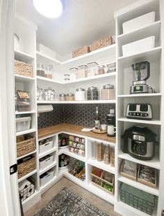 an organized pantry with white shelving and lots of storage