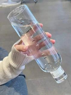 a person holding a water bottle in their hand