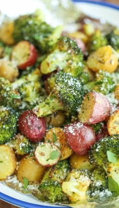 a plate full of broccoli and potatoes covered in powdered sugar on a wooden table