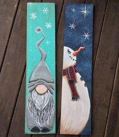 two snowmen painted on wooden boards sitting next to each other