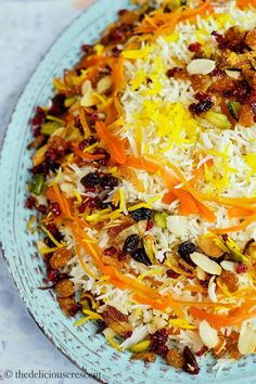 a blue plate topped with lots of different types of food on top of a table