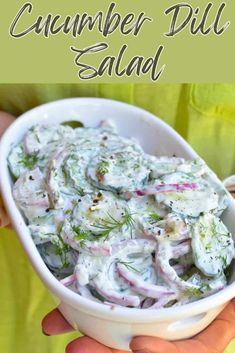 a white bowl filled with cucumber dill salad on top of a table