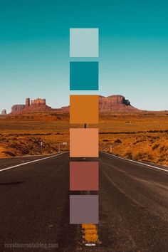 an empty road in the middle of nowhere with mountains in the background and blue sky