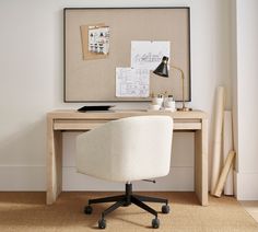 an office chair sits in front of a desk with a computer on it and a cork board behind it