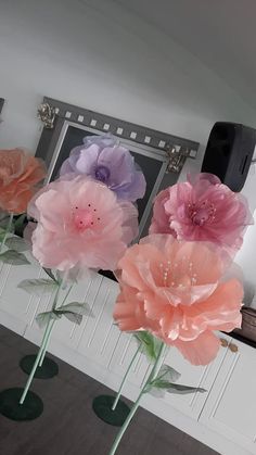 three large pink and purple flowers in vases