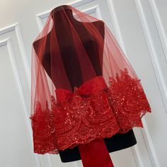 a red wedding veil on top of a mannequin