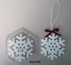 two snowflakes are hanging on the wall next to a plastic ornament