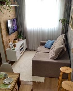 a living room filled with furniture and a flat screen tv sitting on top of a wooden table