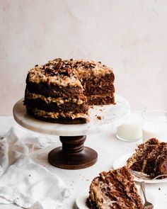 a chocolate cake on a plate with one slice cut out and the rest half eaten