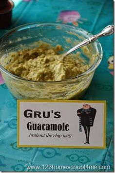 a bowl of guacamole sits on a table next to a sign that says gru's guacamole without the chip