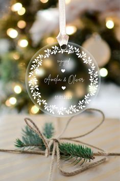 a glass ornament with the words happily married on it next to a christmas tree