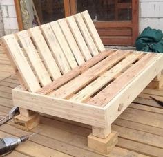 a wooden bench sitting on top of a wooden deck next to a power cord and drill