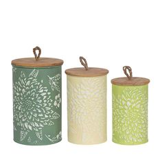 three tin canisters with lids and handles, each decorated with an intricate flower design