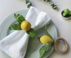 two lemons are sitting on top of a napkin with green leaves and some other decorations