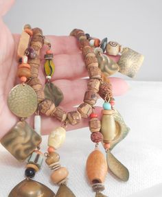 This Boho Tribal necklace has it all with hand carved wood beads, real pearls, end hammered real brass dangles, glass beads, bone beads, and all kinds of wood beads with a long strand in the center and graduated length strands on each side measures 17 inches from end to end with a brass spring roll clasp has many kinds and shapes beads...and colors is linked and connected with brass findings is quite the beauty! there was a lot of it to capture in pics, so they do not do this necklace justice If Rustic Wooden Bead Necklaces For Festivals, Rustic Wooden Beads Necklace For Festival, Rustic Wooden Bead Necklace For Festivals, Bronze Bohemian Necklace With Large Beads, Bohemian Bronze Necklace With Large Beads, Bronze Bohemian Beaded Necklace With Wooden Beads, Bohemian Bronze Beaded Necklace With Wooden Beads, Rustic Wooden Beads Jewelry For Festival, Bohemian Bronze Necklace With Wooden Beads