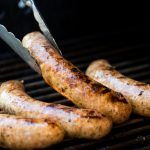 some sausages are being cooked on a grill