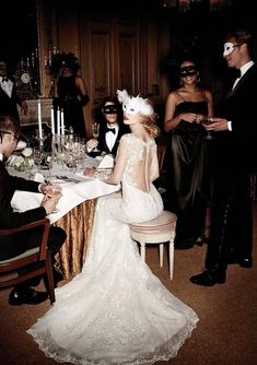 a man and woman sitting at a table in front of each other with glasses on