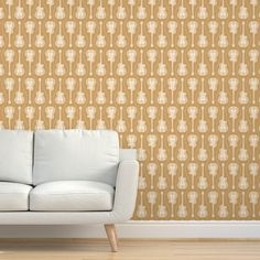 a white couch sitting in front of a wall with an intricate pattern on it's side