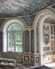 an ornate room with blue and white wallpaper, arched windows, and checkered flooring