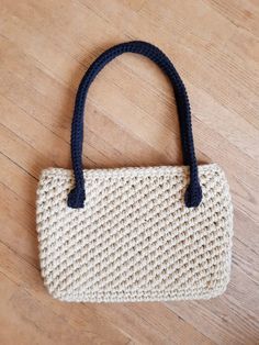 a crocheted purse sitting on top of a wooden floor