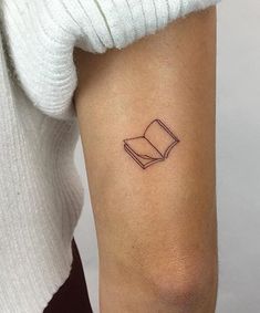 a woman's arm with a book tattoo on the left side of her arm