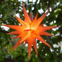 an origami star hanging from a tree