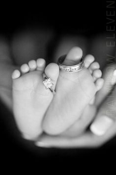 a baby's feet with a ring on top of it and a person holding their hand