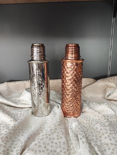 two old fashioned salt and pepper shakers on a bed