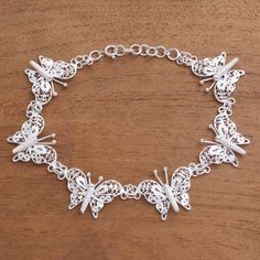 Glittering in the light sterling silver filigree is handcrafted to form six butterflies that encircle the wrist. Javanese artisan Selly Sagita creates this intricately-crafted accessory.