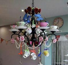 a chandelier with tea cups and saucers hanging from it's arms