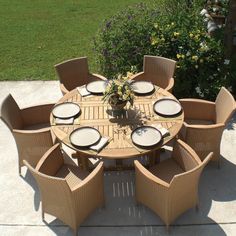 an outdoor table and chairs with plates on it in the middle of a patio area