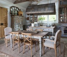 an old fashioned kitchen and dining room are in this house with stone flooring, wood beams