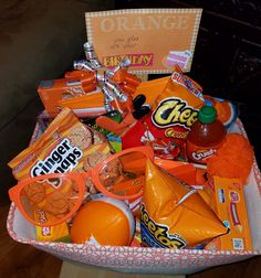 an orange basket filled with candy and snacks