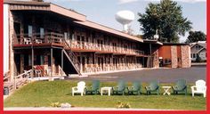 several lawn chairs in front of a motel with balconies on the balconys