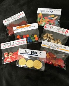 four bags filled with candy and candies sitting on top of a black tablecloth