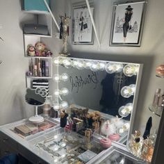 a vanity with lighted lights and various items on it in front of a mirror that says beautiful