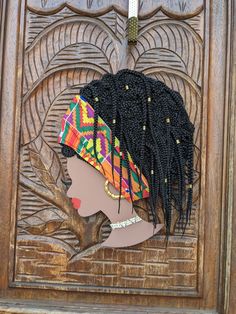 an african woman's head with braids and beads on it, in front of a carved wooden door