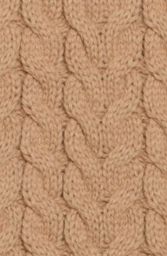 close up view of the texture of a knitted fabric with wavy braiding in beige tones