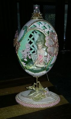 an ornament is sitting on top of a wooden table with a doll in the center