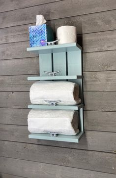 a blue shelf with two rolls of toilet paper on it