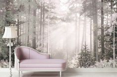 a pink couch sitting in front of a forest wall mural