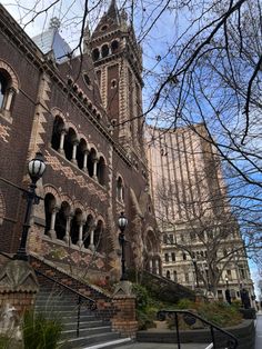 an old brick building with a clock tower in the background and stairs leading up to it